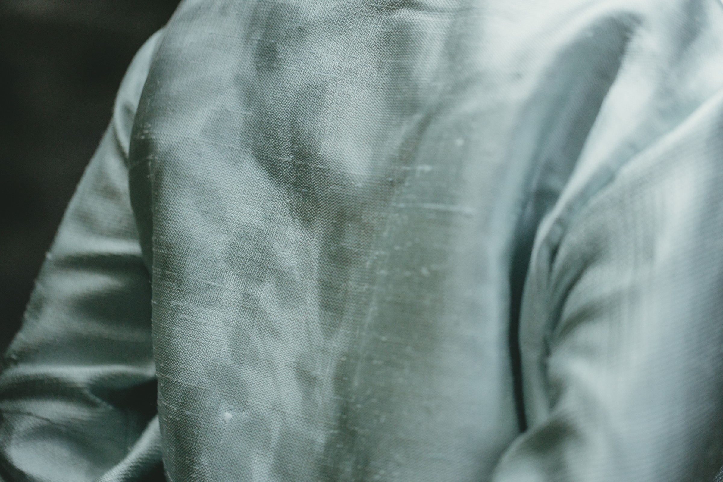 A pear set on a yellow plate upon a soft white canvas texture.